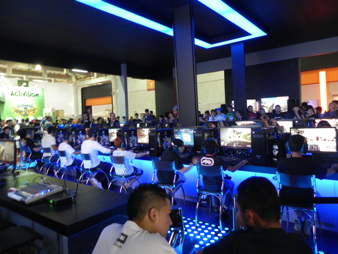 Visitantes testando o Battlefield 4 no "Centro de Comando" do estande da EA/Warner