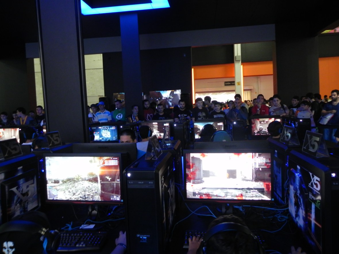 Visitantes testando o Battlefield 4 no "Centro de Comando" do estande da EA/Warner