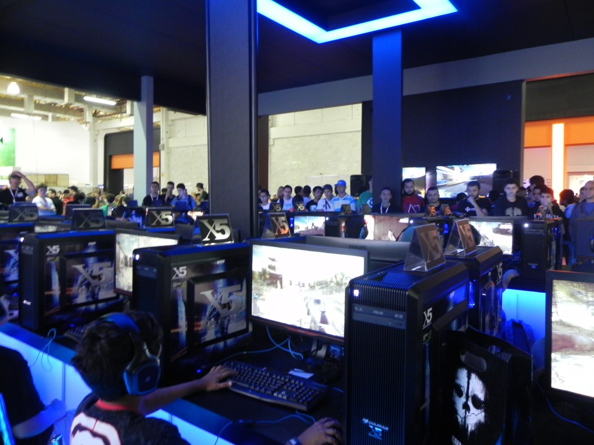 Visitantes testando o Battlefield 4 no "Centro de Comando" do estande da EA/Warner